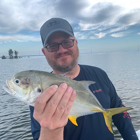 Dustin Goodman holding a jack caught on the water